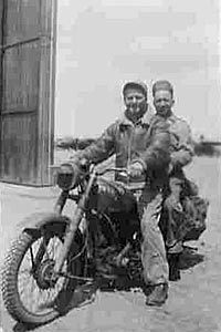 Ground crew on motorcycle near one of Membury's hangars